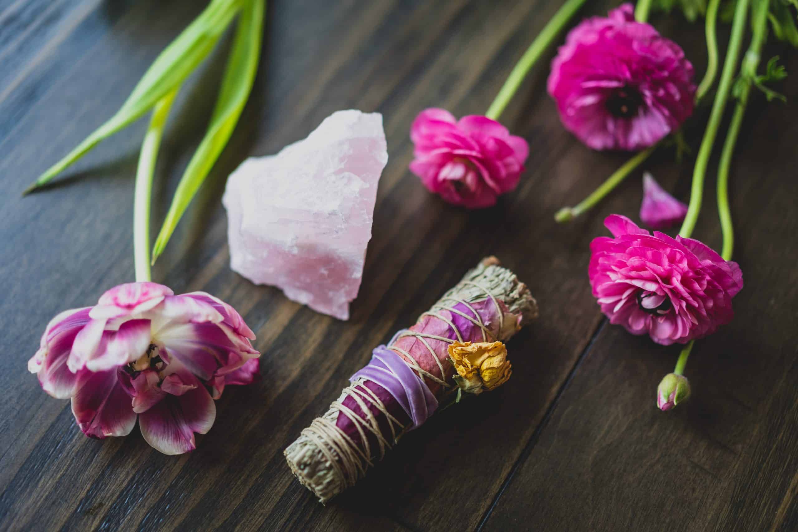 Rose quartz crystal with pink flowers and sage