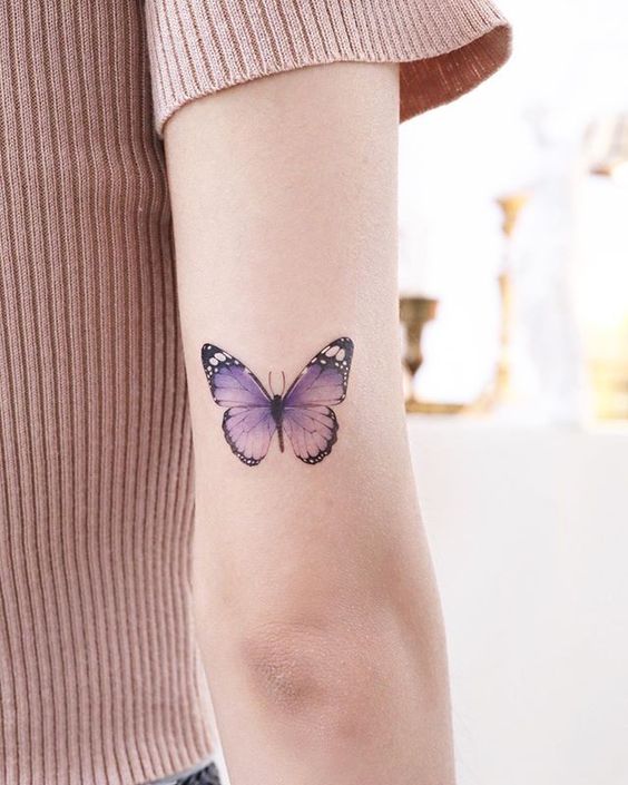purple butterfly tattoo on arm