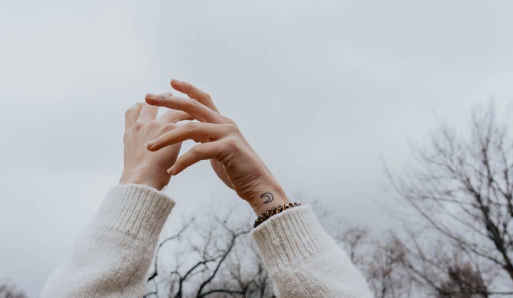 simple crescent moon wrist tattoo