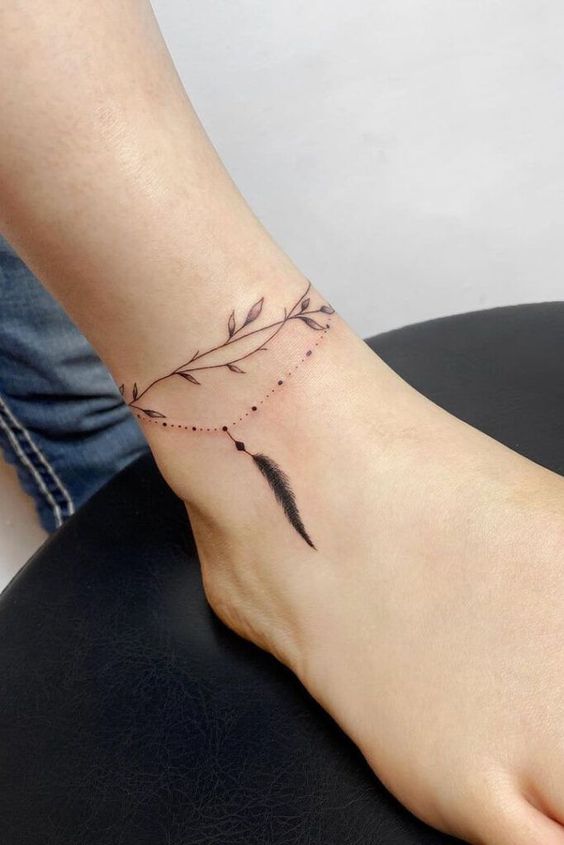 minimalist feather olive branch tattoo design on ankle