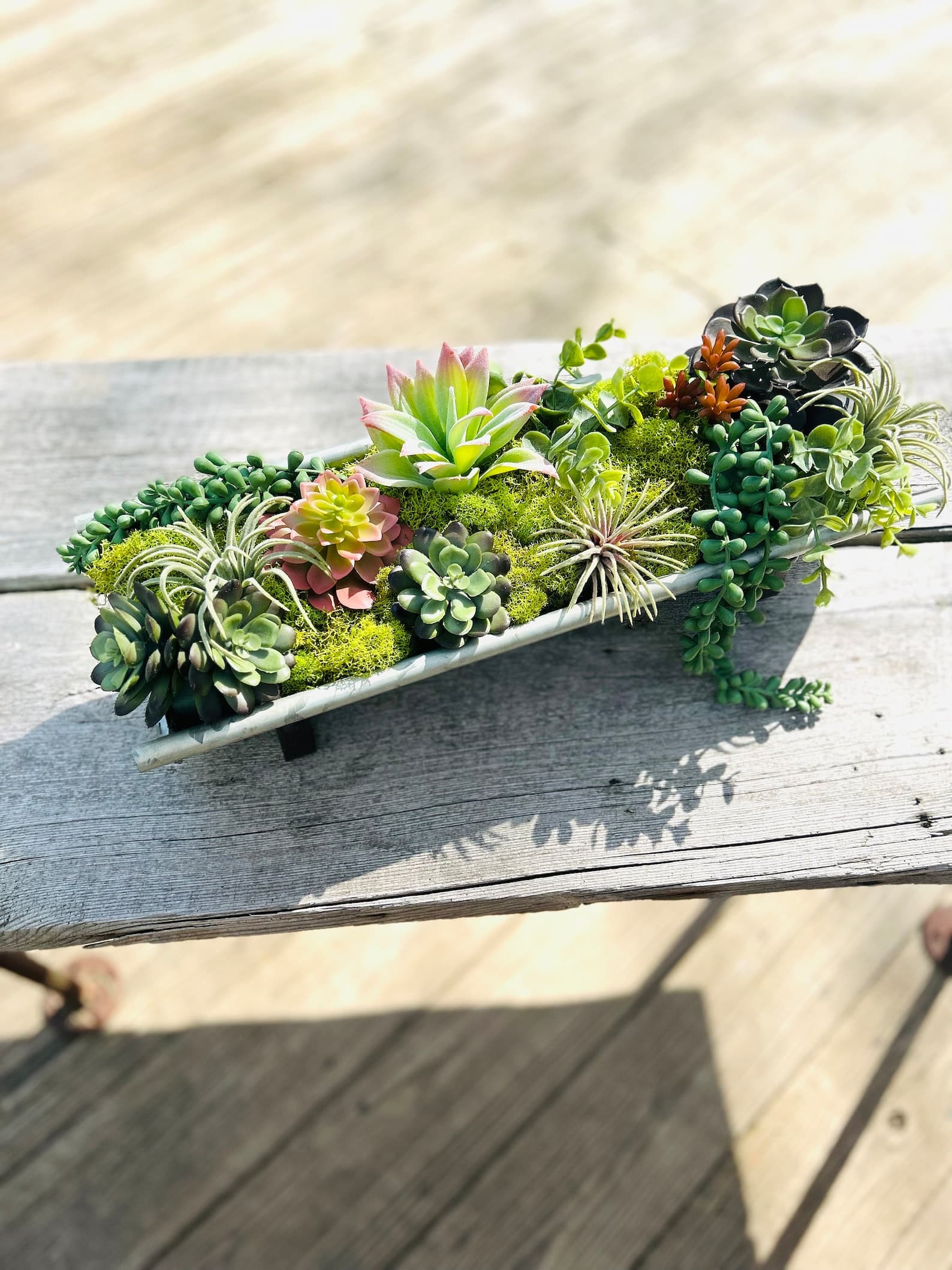 faux succulent arrangement in concrete tray
