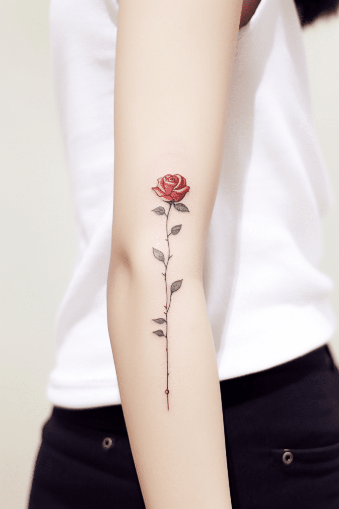 red minimalist rose tattoo on arm long thin tattoo
