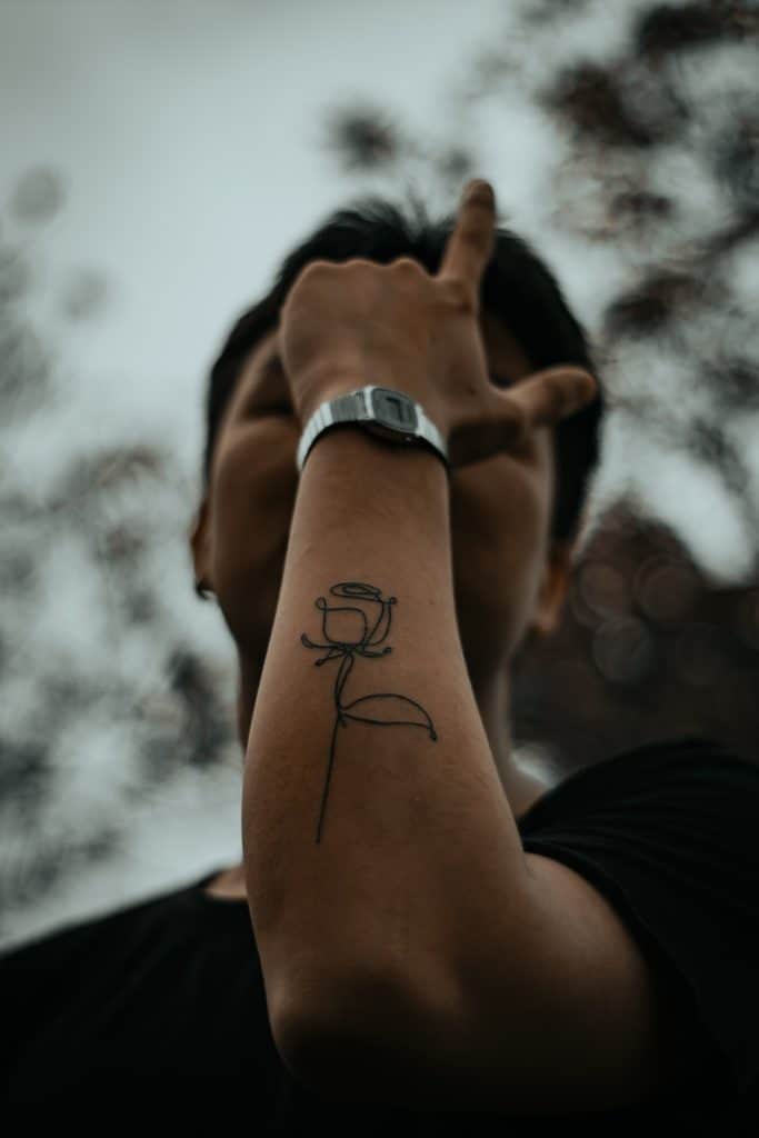 line art rose tattoo on man