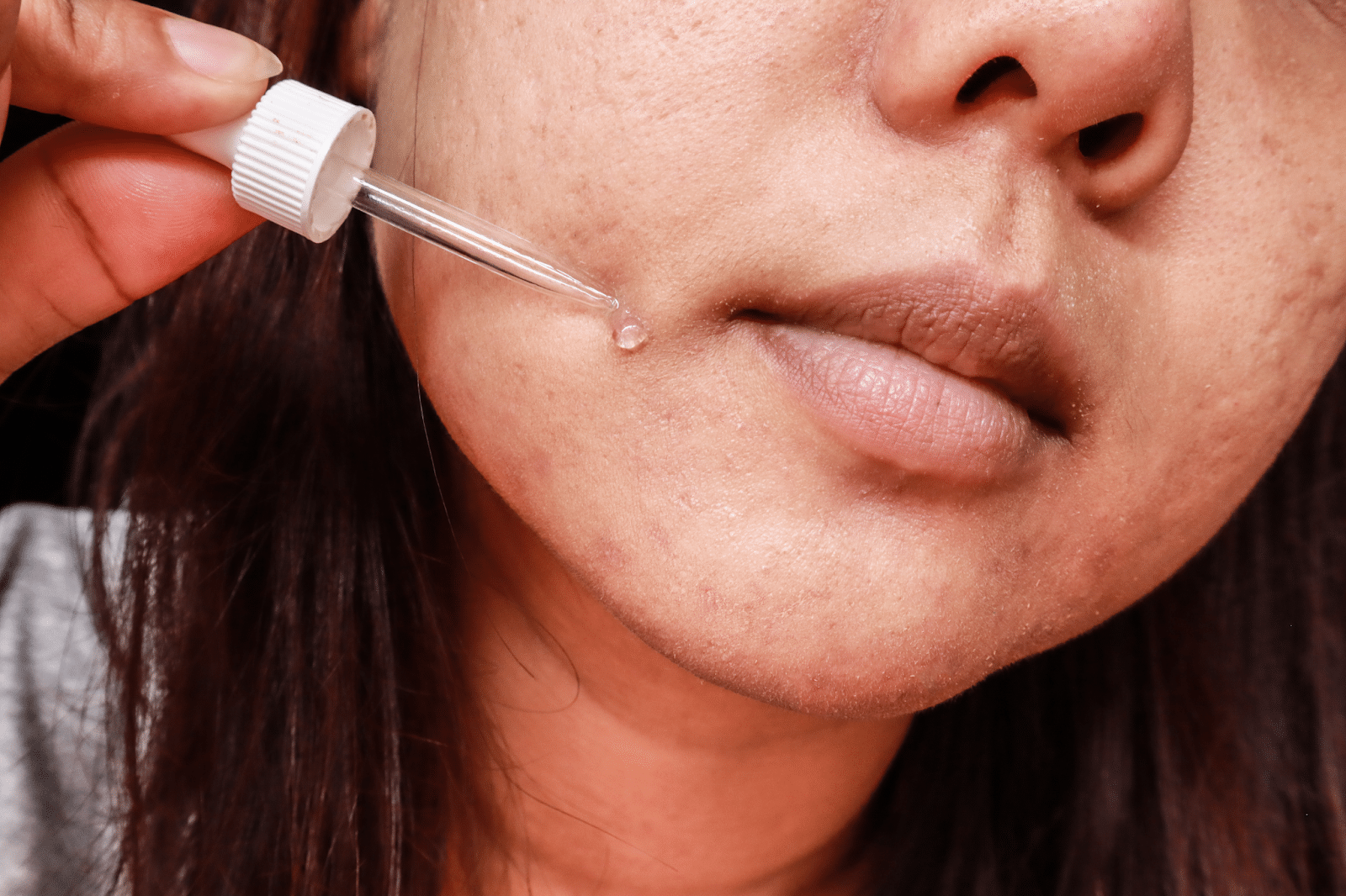applying vitamin c serum to skin