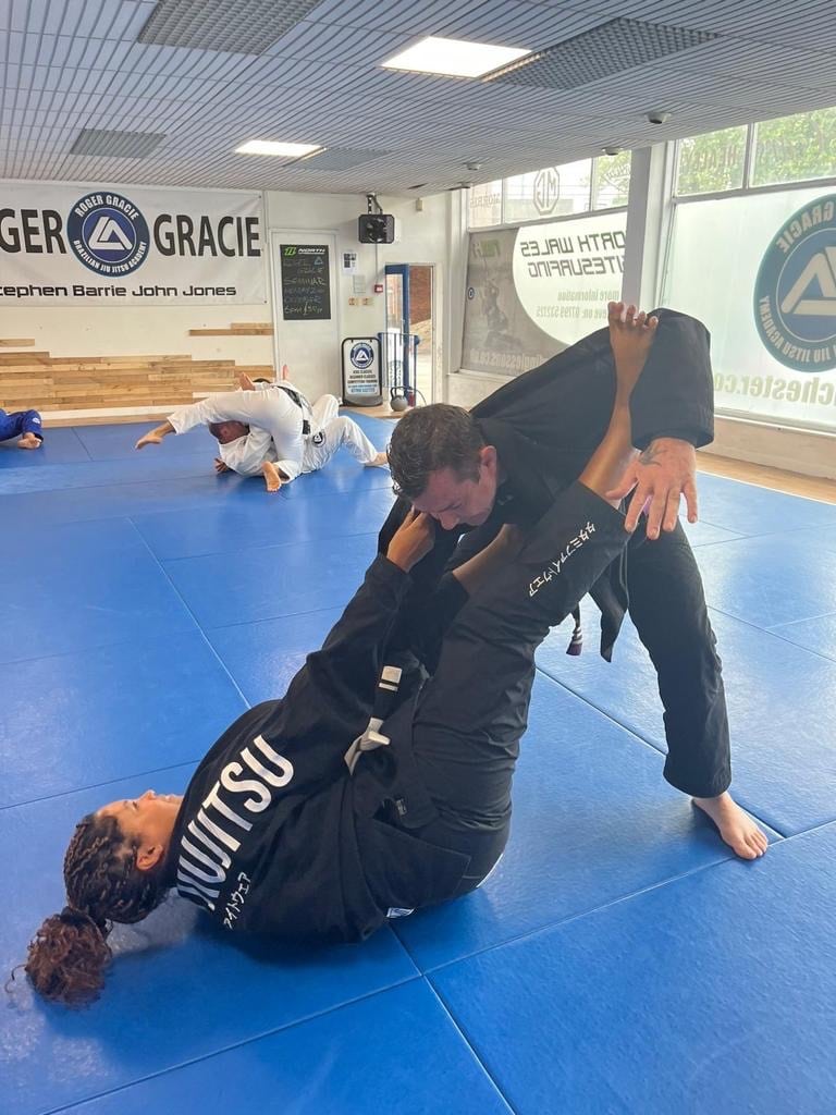 Woman and man practicing jiu jitsu